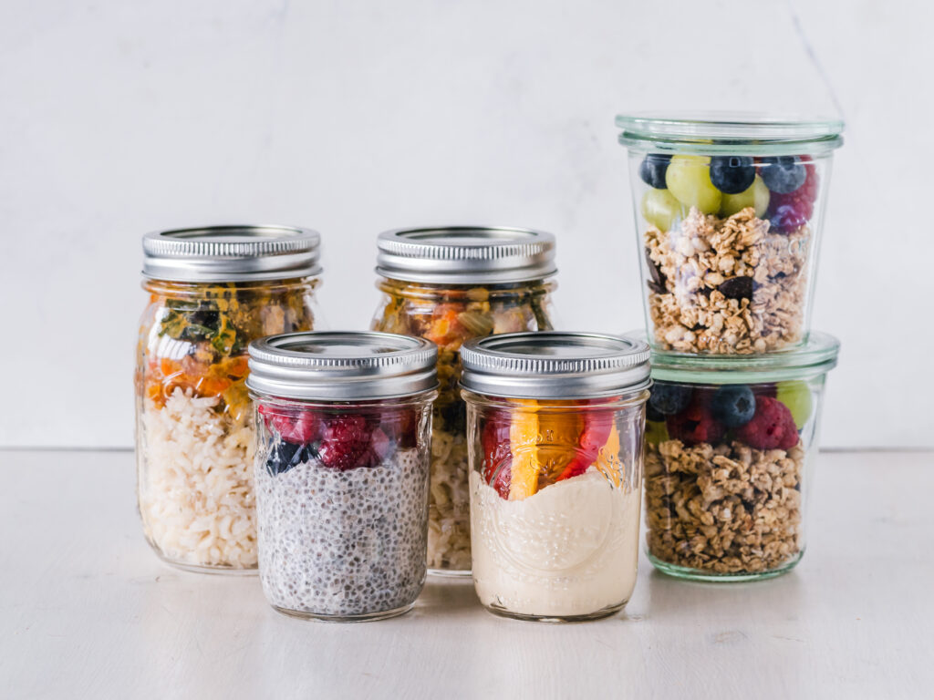Prepared breakfast and lunch foods arranged in individual meal-prep containers.