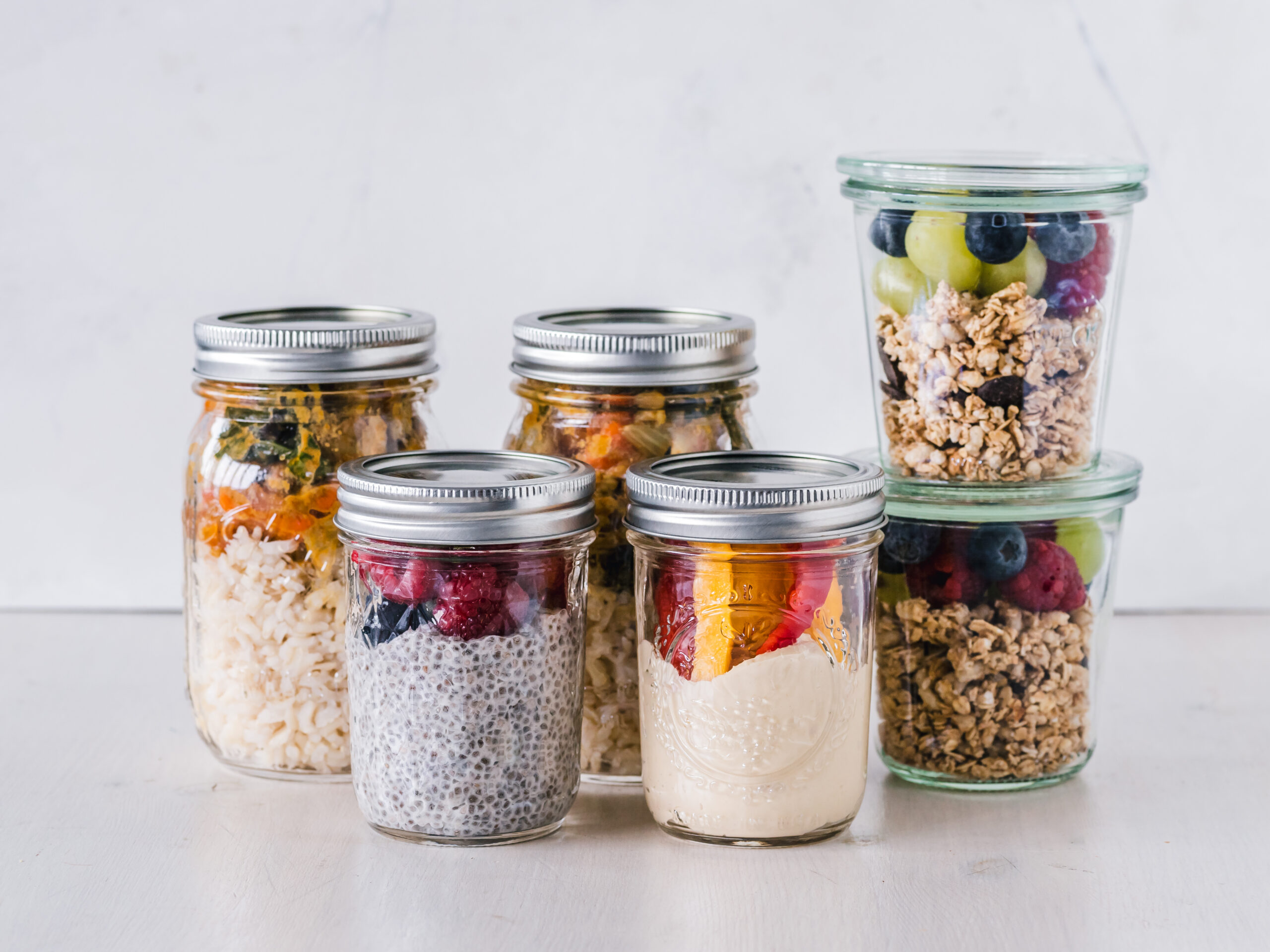Prepared breakfast and lunch foods arranged in individual meal-prep containers.